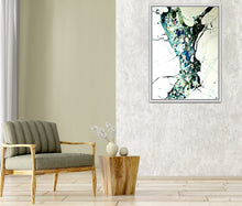 Load image into Gallery viewer, A framed abstract painting hangs on a textured light gray wall in a modern living room setting, featuring a gray upholstered wooden armchair and a rustic wood side table with a vase.

