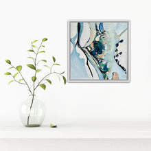 Load image into Gallery viewer, A framed abstract painting with blue, teal, black, and cream brushstrokes hangs on a white wall above a white shelf. A clear glass vase with green stems and leaves sits on the shelf to the left.
