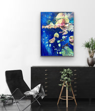 Load image into Gallery viewer, Abstract oil painting, mixed media on canvas. Royal blue with shades of green, pink and yellow. Shown in situ on a white wall above a black sideboard and chair.
